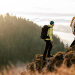 two hikers in nature climbing a mountain