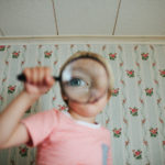 child looking through magnifying glass featured image