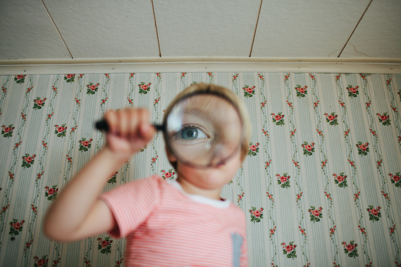 child looking through magnifying glass featured image