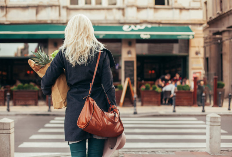 Woman with groceries crossing the street featured image