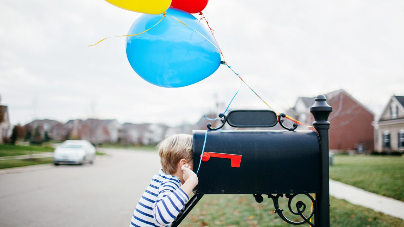 little boy looking in mailbox featured image