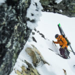 Skiier hiking up a snowy mountain outdoors featured image