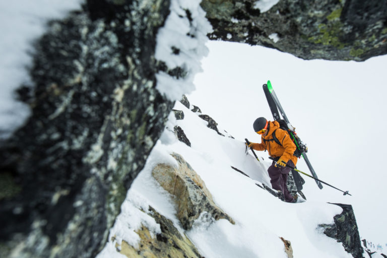 Skiier hiking up a snowy mountain outdoors featured image