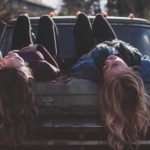 girls lying on car featured image