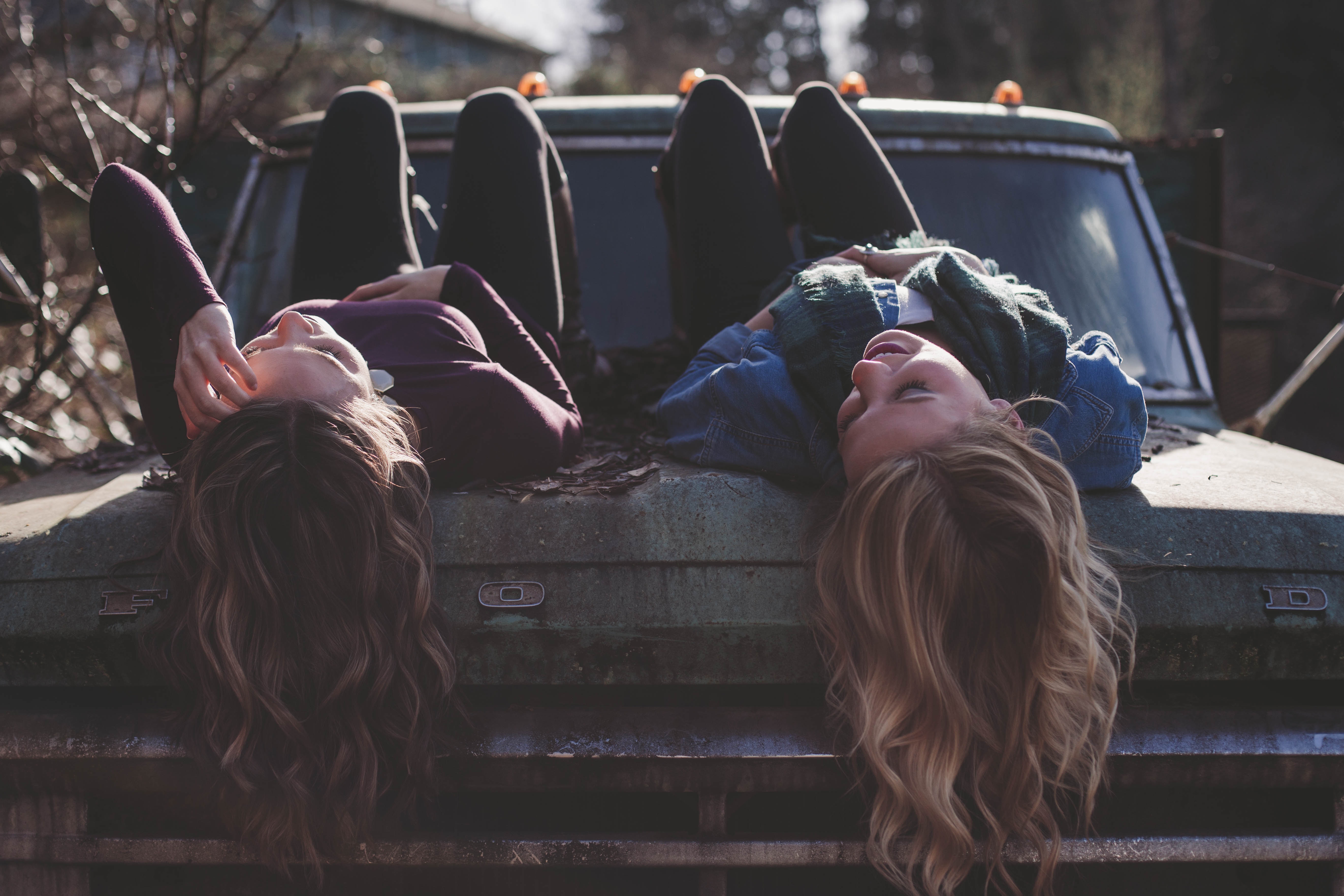 girls lying on car featured image