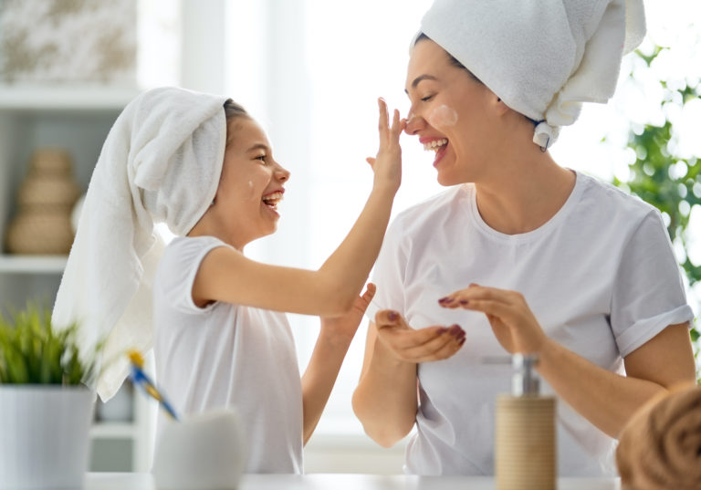 happy-mother-and-daughter-applying-face-cream